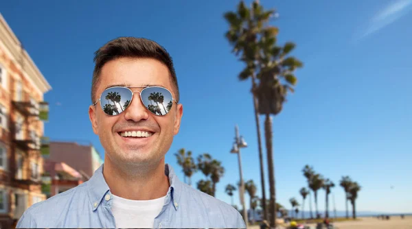 Uomo sorridente in occhiali da sole sulla spiaggia di venezia — Foto Stock