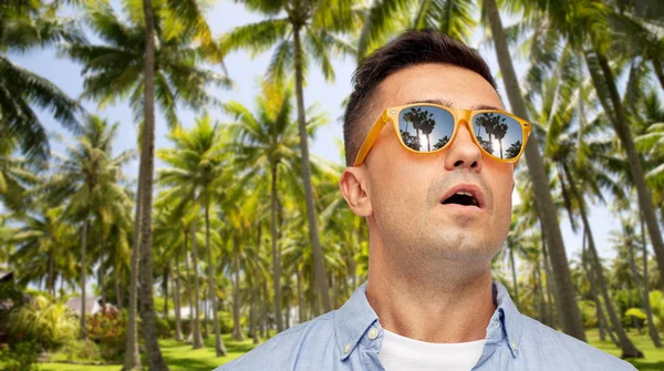 Homme surpris en lunettes de soleil sur la plage tropicale — Photo