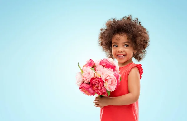 Glad liten afroamerikanska flicka med blommor — Stockfoto