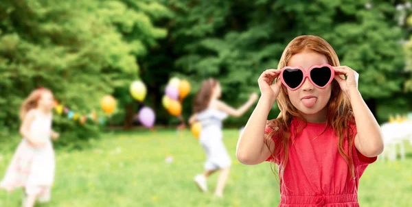 Freche rothaarige Mädchen mit herzförmiger Sonnenbrille — Stockfoto