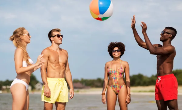 Amigos jogando com bola de praia no verão — Fotografia de Stock