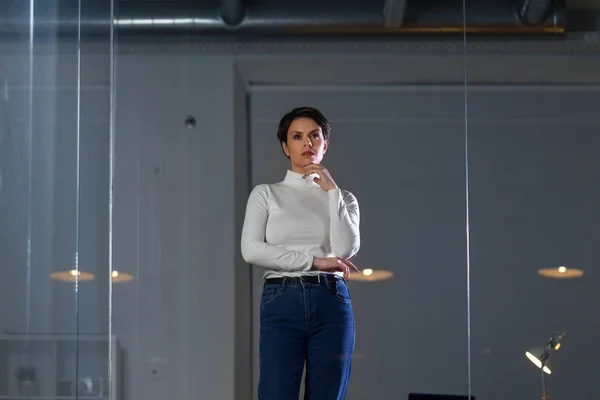 Femme d'affaires regarde mur de verre au bureau de nuit — Photo