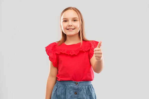 Krásná usměvavá dívka ukazuje palec — Stock fotografie