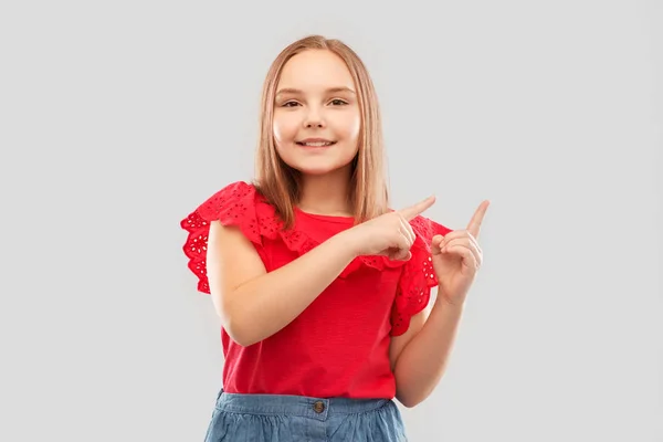 Smiling girl pointing fingers to something — Stock Photo, Image