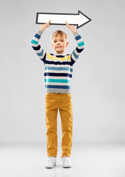 Chlapec držící velkou bílou šipku ukazující vpravo — Stock fotografie
