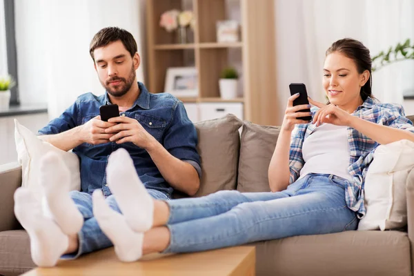 Casal com smartphones em casa — Fotografia de Stock