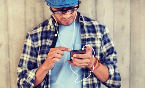 Man med hörlurar och smartphone lyssnar musik — Stockfoto