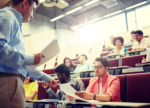 Teacher giving tests to students at lecture — Stock Photo, Image