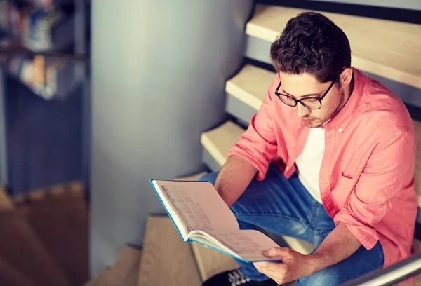 Studentka kluk nebo mladý muž čtení knih v knihovně — Stock fotografie