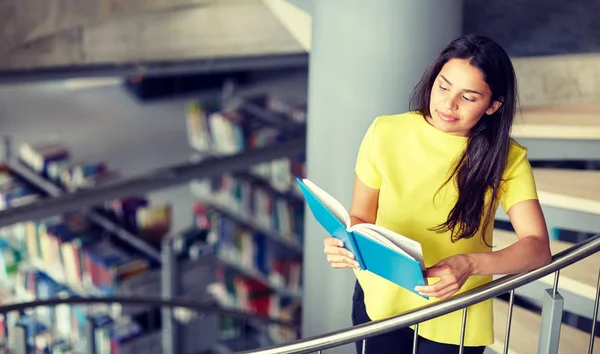 Estudiante de secundaria chica leyendo libro en la biblioteca —  Fotos de Stock