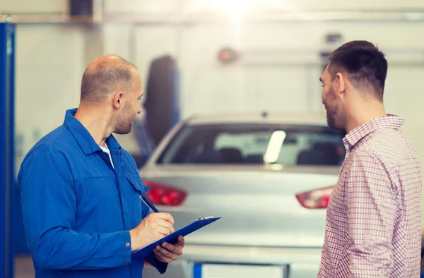 Auto mekaniker med Urklipp och man på bilverkstad — Stockfoto