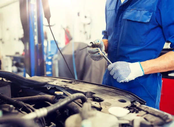 Monteur met moersleutel reparatie auto op de werkplaats — Stockfoto