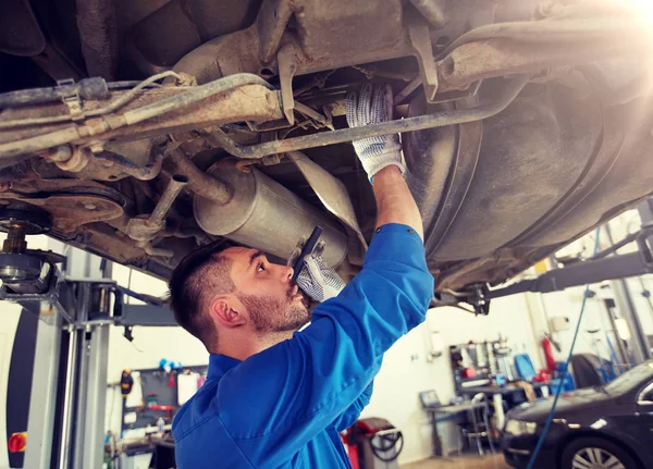 Szerelő férfi zseblámpával javítás autó a boltban — Stock Fotó