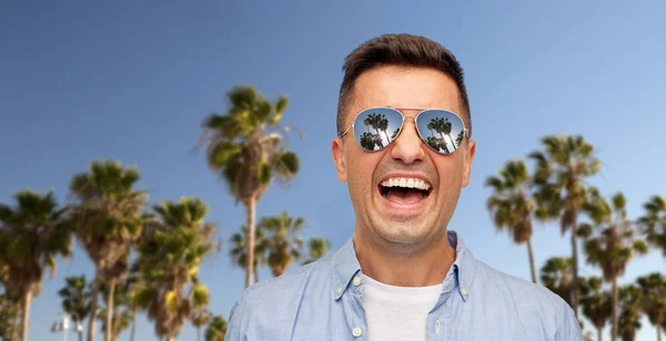笑的人在棕榈树的太阳镜 — 图库照片