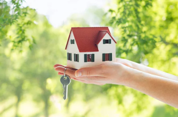 Nahaufnahme der Hände, die Hausmodell und Schlüssel halten — Stockfoto