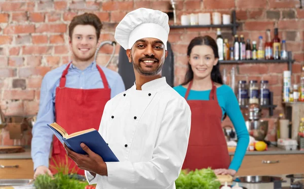 Male indian chef reading cookbook at cooking class — Stock Photo, Image