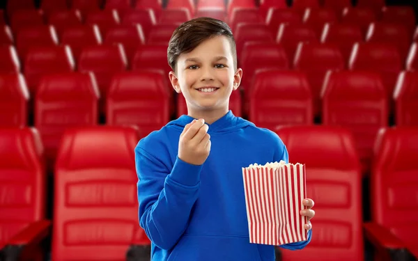 Happy smiling boy eating popcorn at movie theater — Stockfoto