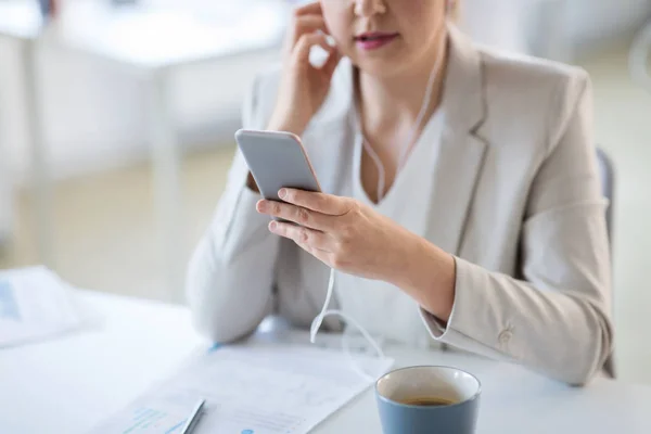 Businesswoman with earphones and smartphone — Stock Photo, Image