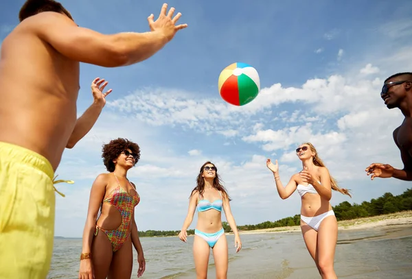 Happy vrienden spelen bal op zomer-strand — Stockfoto