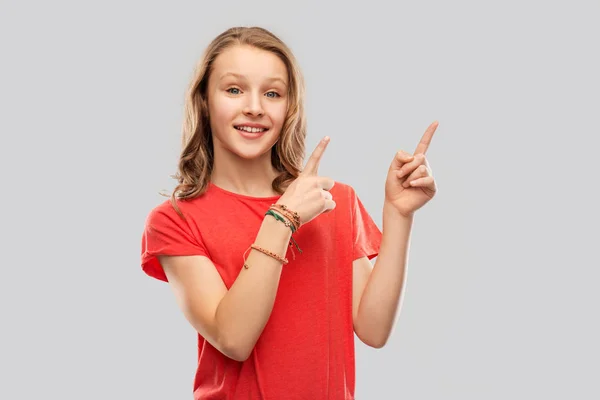 Sonriente adolescente apuntando con los dedos a algo — Foto de Stock