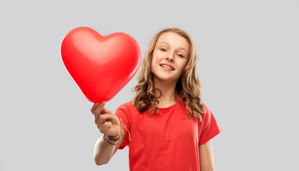 Χαμογελώντας εφηβικό κορίτσι με κόκκινο μπαλόνι σε σχήμα καρδιάς — Φωτογραφία Αρχείου