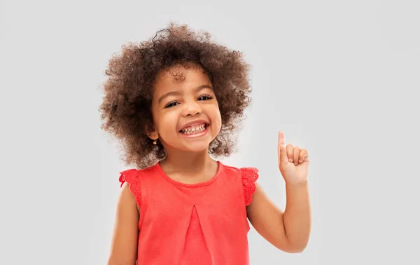 Niña afroamericana apuntando con el dedo hacia arriba —  Fotos de Stock
