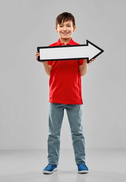 Boy holding big white rightwards thick arrow — Stock Photo, Image