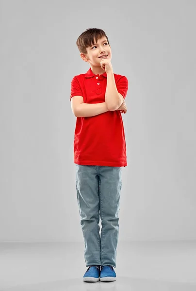 Niño pensante en camiseta de polo rojo — Foto de Stock