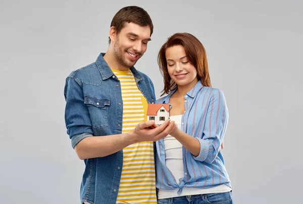 Улыбающаяся пара держит модель дома — стоковое фото