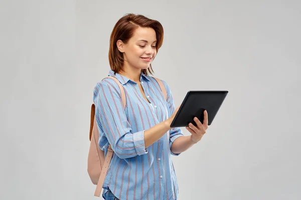 Glückliche Frau mit Rucksack und Tablet-Computer — Stockfoto