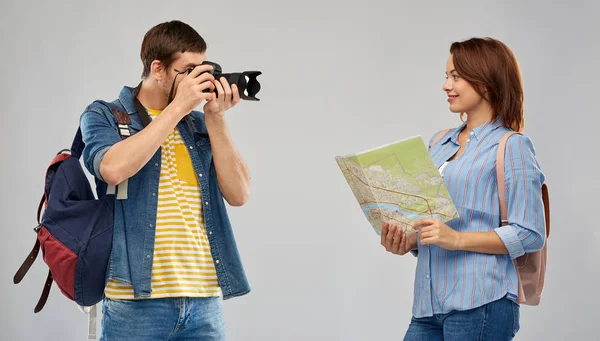 Feliz pareja de turistas con mochilas y cámara —  Fotos de Stock