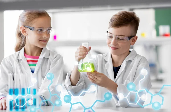 Niños con tubos de ensayo que estudian química en la escuela — Foto de Stock