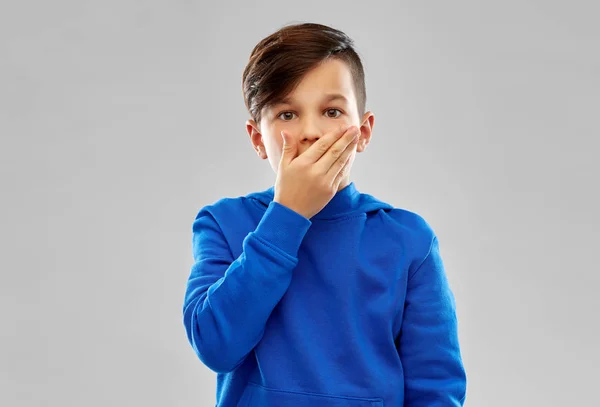 Shocked boy closing mouth by hand — Stock Photo, Image