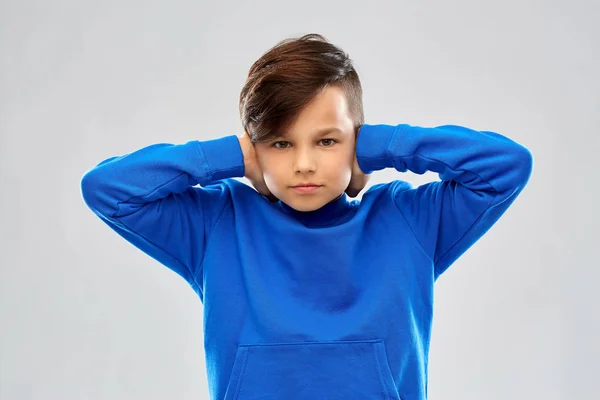 Niño estresado en suéter azul orejas de cierre por las manos —  Fotos de Stock