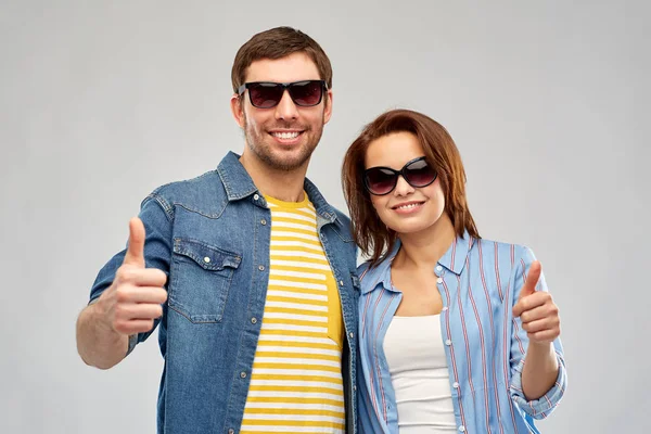 Heureux couple dans les lunettes de soleil montrant pouces vers le haut — Photo