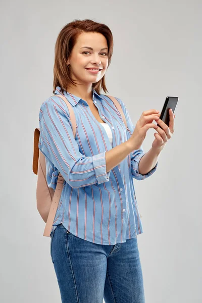 Lycklig kvinna med ryggsäck och smartphone — Stockfoto