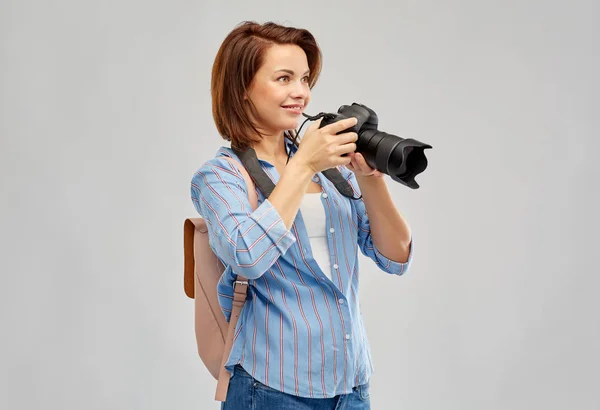 Mulher turística feliz com mochila e câmera — Fotografia de Stock