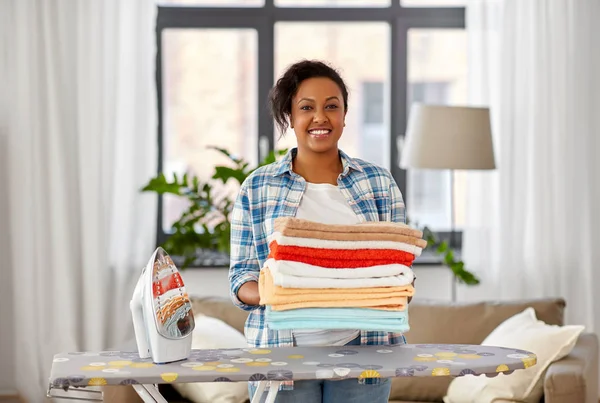 Mujer afroamericana con ropa de cama planchada en casa — Foto de Stock