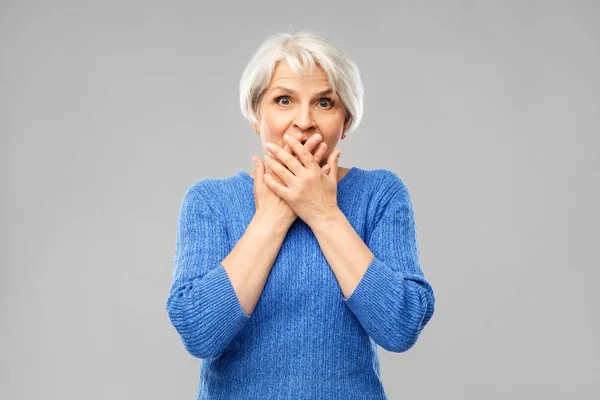 Confusa donna anziana che si copre la bocca per mano — Foto Stock