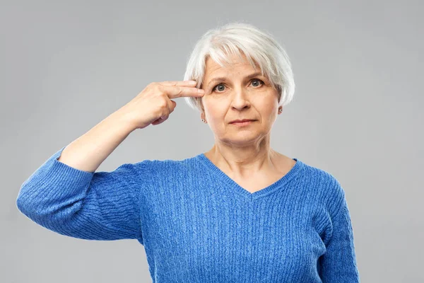 Donna anziana facendo gesto pistola dito — Foto Stock