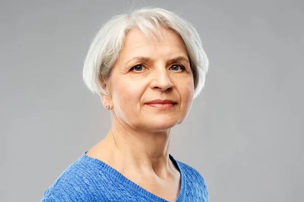 Портрет старшої жінки в синьому светрі над сірим — стокове фото