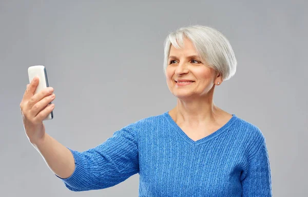 Mosolygós idős nő csinál szelfi okostelefon — Stock Fotó