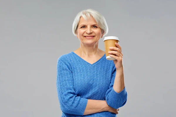 Улыбающаяся пожилая женщина с чашкой кофе на вынос — стоковое фото