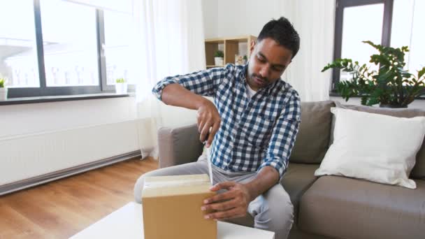 Video blogger masculino abriendo caja de paquetes en casa — Vídeo de stock