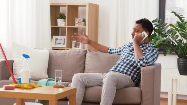 Hombre que llama en el teléfono inteligente después de limpiar casa — Vídeo de stock