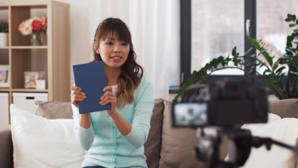 Азиатская блоггер делает видеообзор книги — стоковое видео