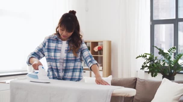 Asian woman ironing bed linen at home — Stock Footage Asian woman ironing bed linen at home Royalty Free Stock Video