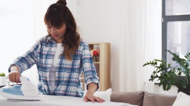 Mujer asiática planchando ropa de cama en casa — Vídeos de Stock