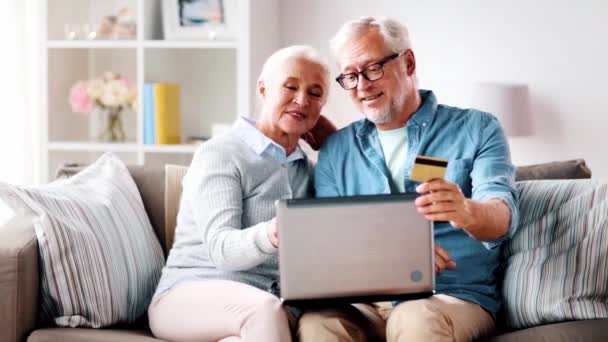 Happy senior couple with laptop and credit card — Stock Video