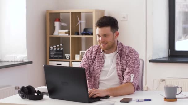 Счастливый молодой человек с ноутбуком в офисе — стоковое видео